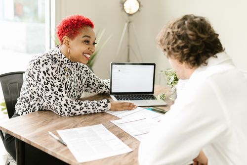 Free Smiling professionals discussing business documents at modern office table. Stock Photo
