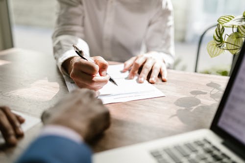 Close-up of a Person Signing a Document