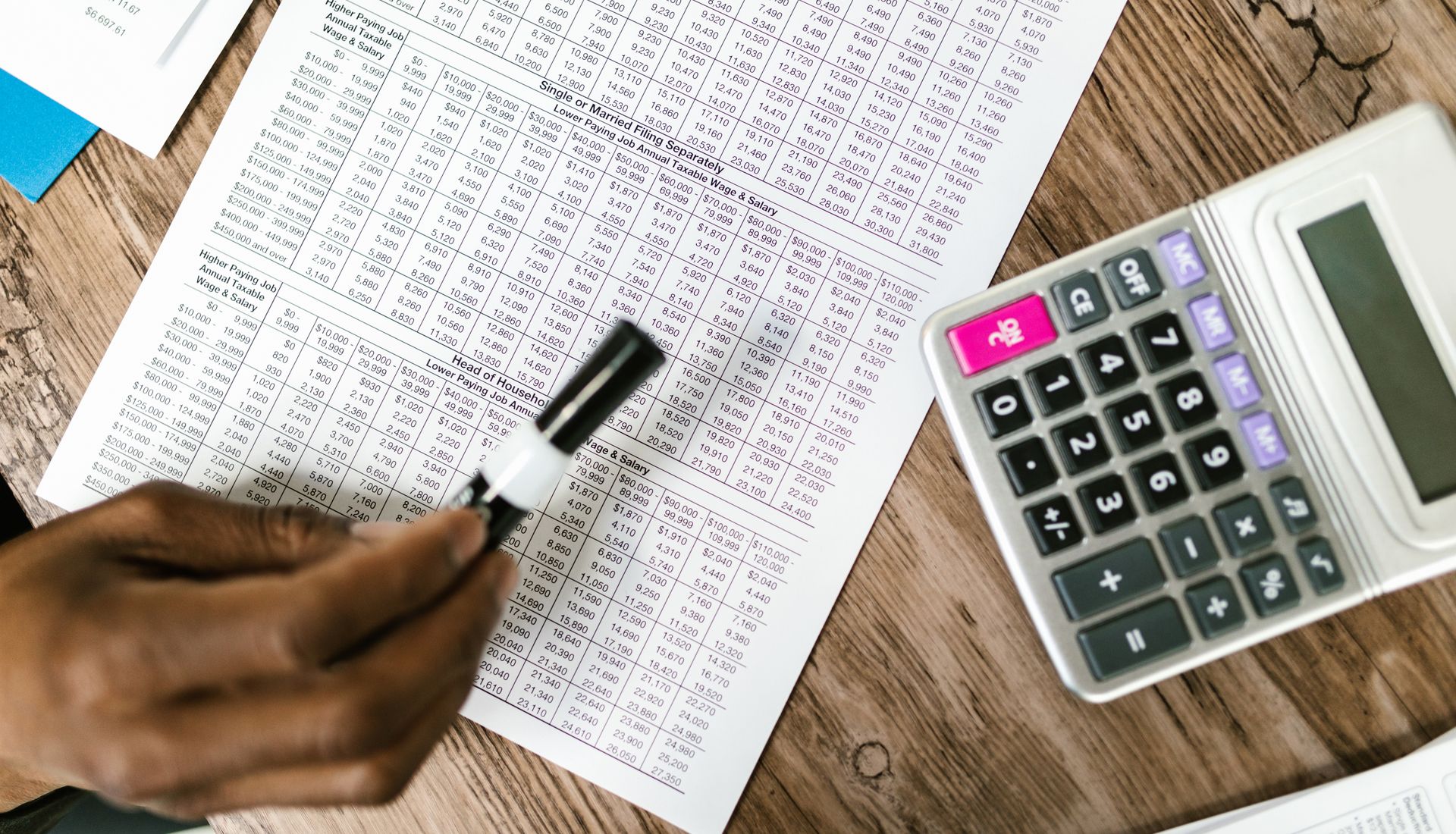 Tax documents and a calculator on a wooden table