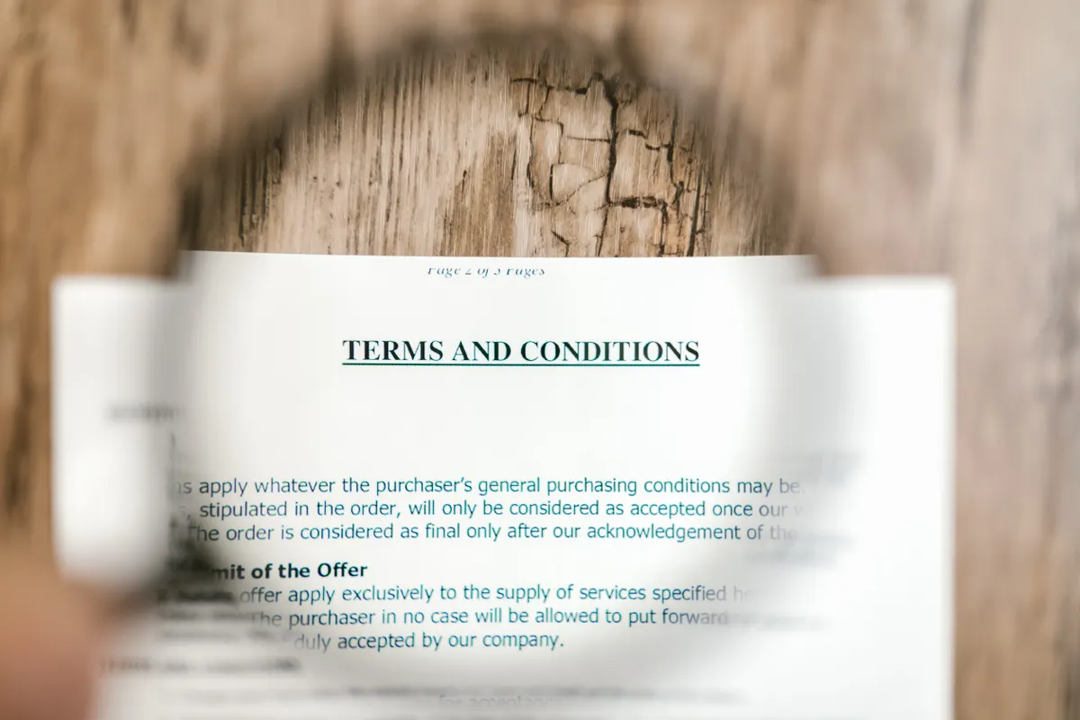 Paper document titled 'TERMS AND CONDITIONS' on a wooden surface, symbolizing the ethical guidelines for using an AI article generator.