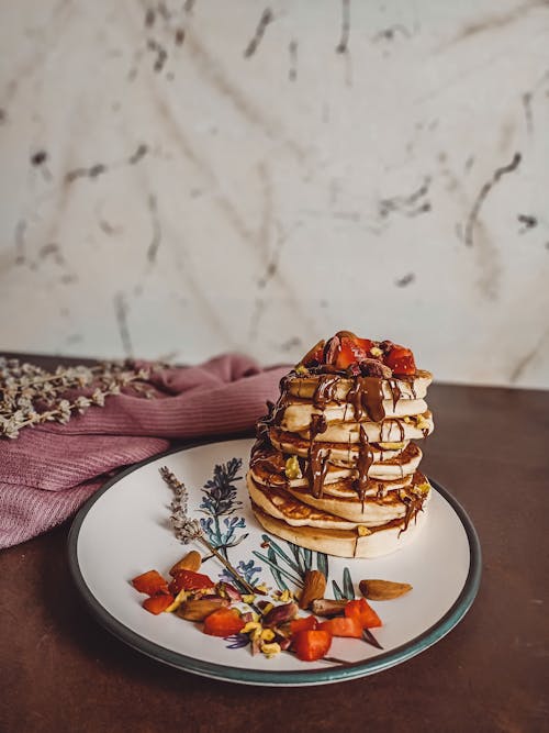 Stack Of Pancakes With Chocolate Syrup and Strawberries On Ceramic Plate