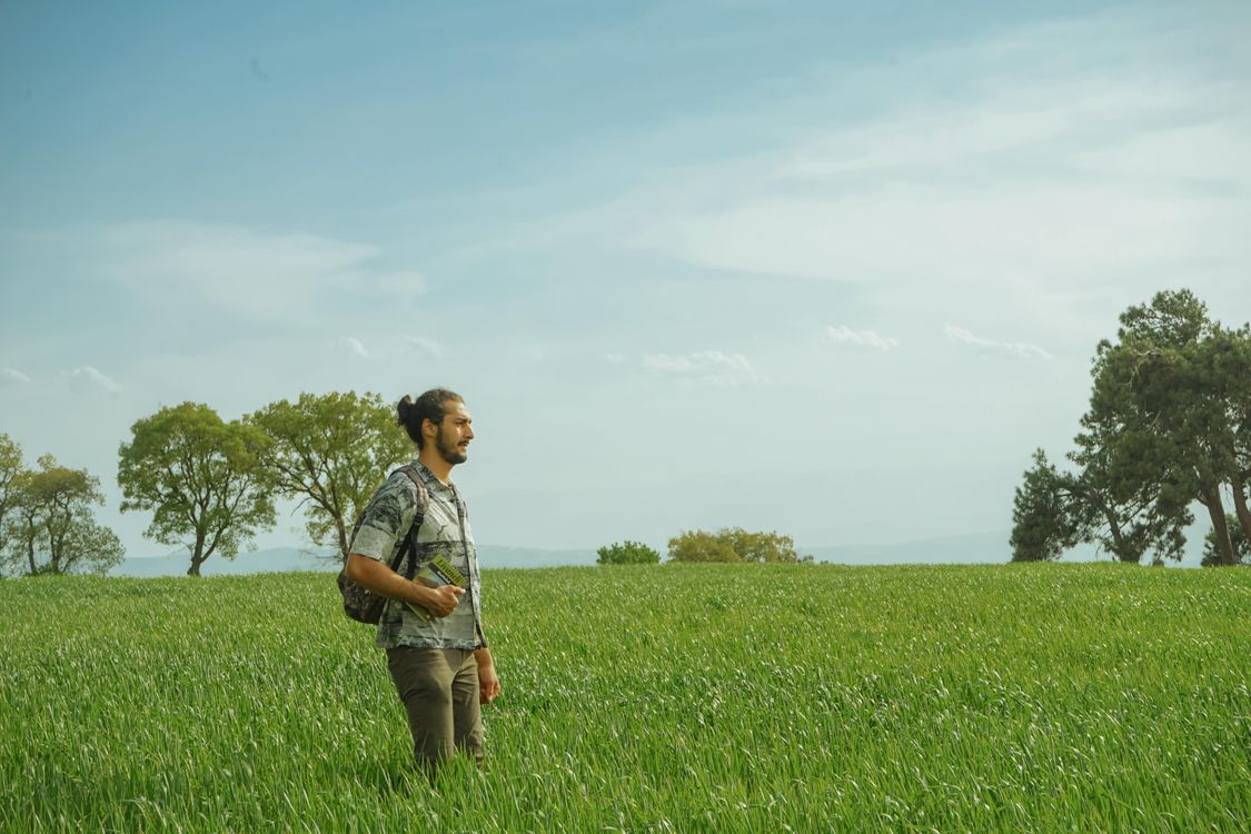 Man Standing on Green Grass Field Under Blue Sky · Free Stock Photo