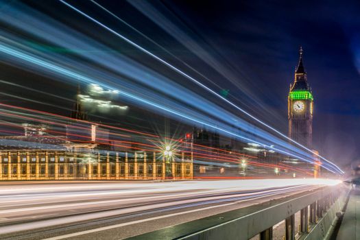 Captivating long-exposure shot of Big Ben with light trails on Westminster Bridge at night.