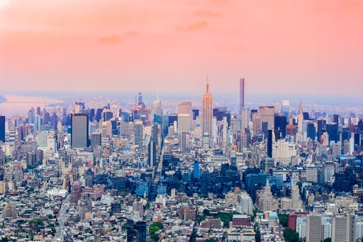 Breathtaking aerial view of New York City skyline with colorful sunset hues, showcasing iconic skyscrapers.