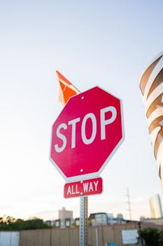 Close-up of a red stop sign in a cityscape, emphasizing urban traffic control.
