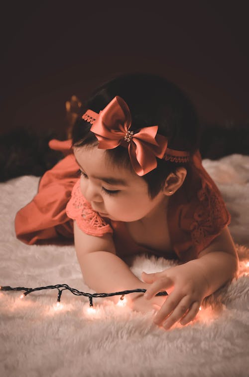 Free A Baby Girl Posing with String Lights Stock Photo