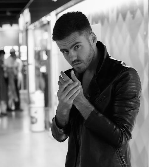 Grayscale Photo of an Attractive Man in Leather Jacket