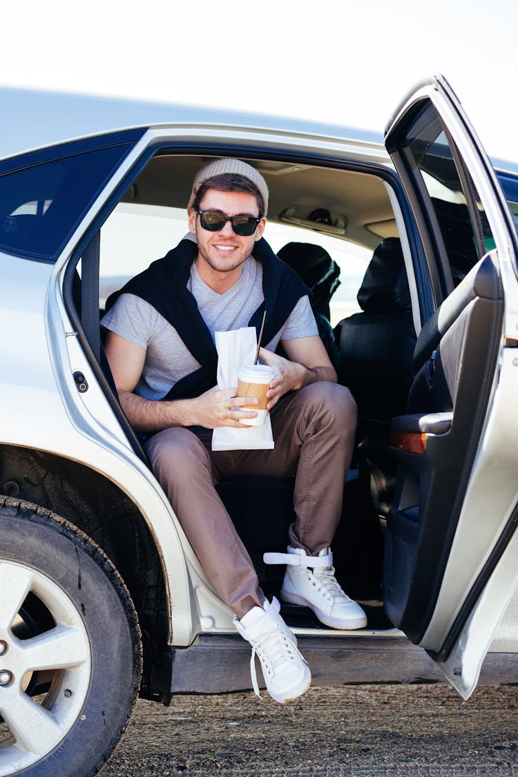 A Happy Man Sitting In The Back Seat Of A Car