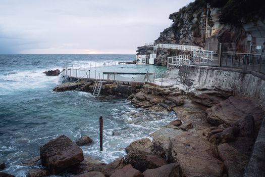 A breathtaking view of Bronte Beach ocean pool with crashing waves against rocky coastline.