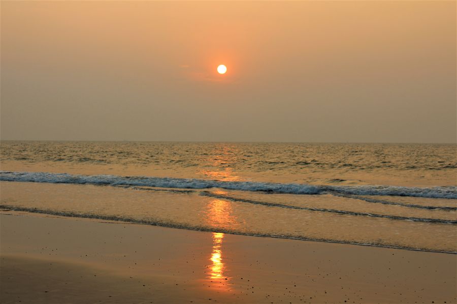 Tranquil evening at the beach with a golden sunset and gentle waves.