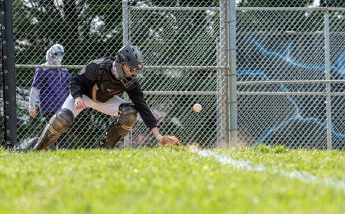 Free A catcher in full gear reaches for a baseball on a sunny field in Columbia, MD. Stock Photo
