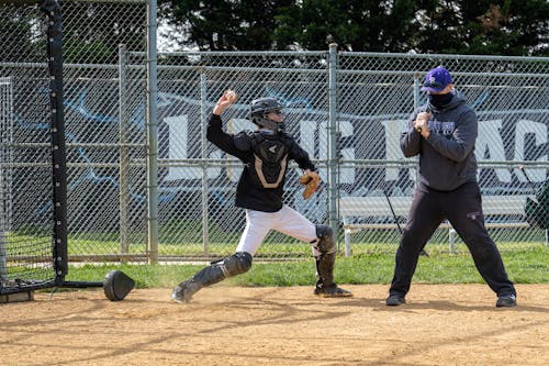 Free Man Throwing a Ball Beside a Baseball Hitter Stock Photo