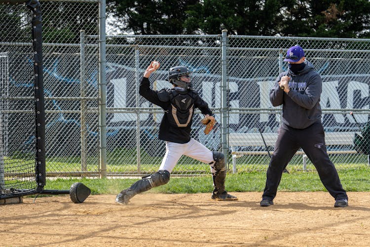 Man Throwing A Ball Beside A Baseball Hitter