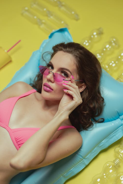 Woman in Pink Bikini Lying on Blue Inflatable