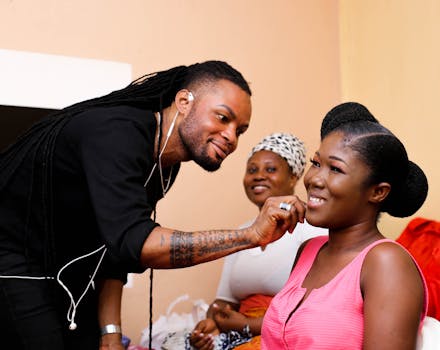Makeup artist skillfully applying cosmetics to a smiling woman in a lively setting.