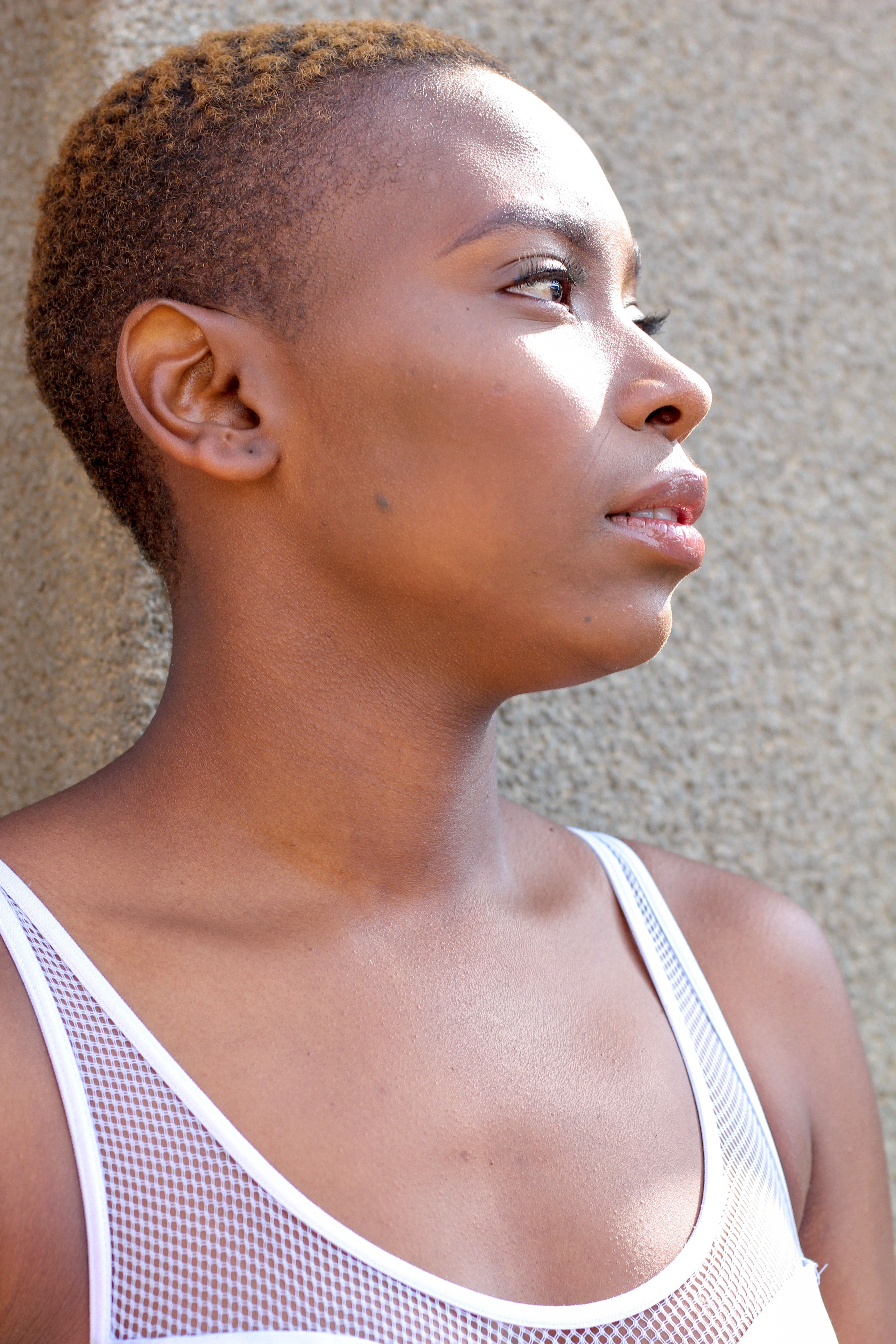 Profile portrait of a woman in deep thought against a textured wall.
