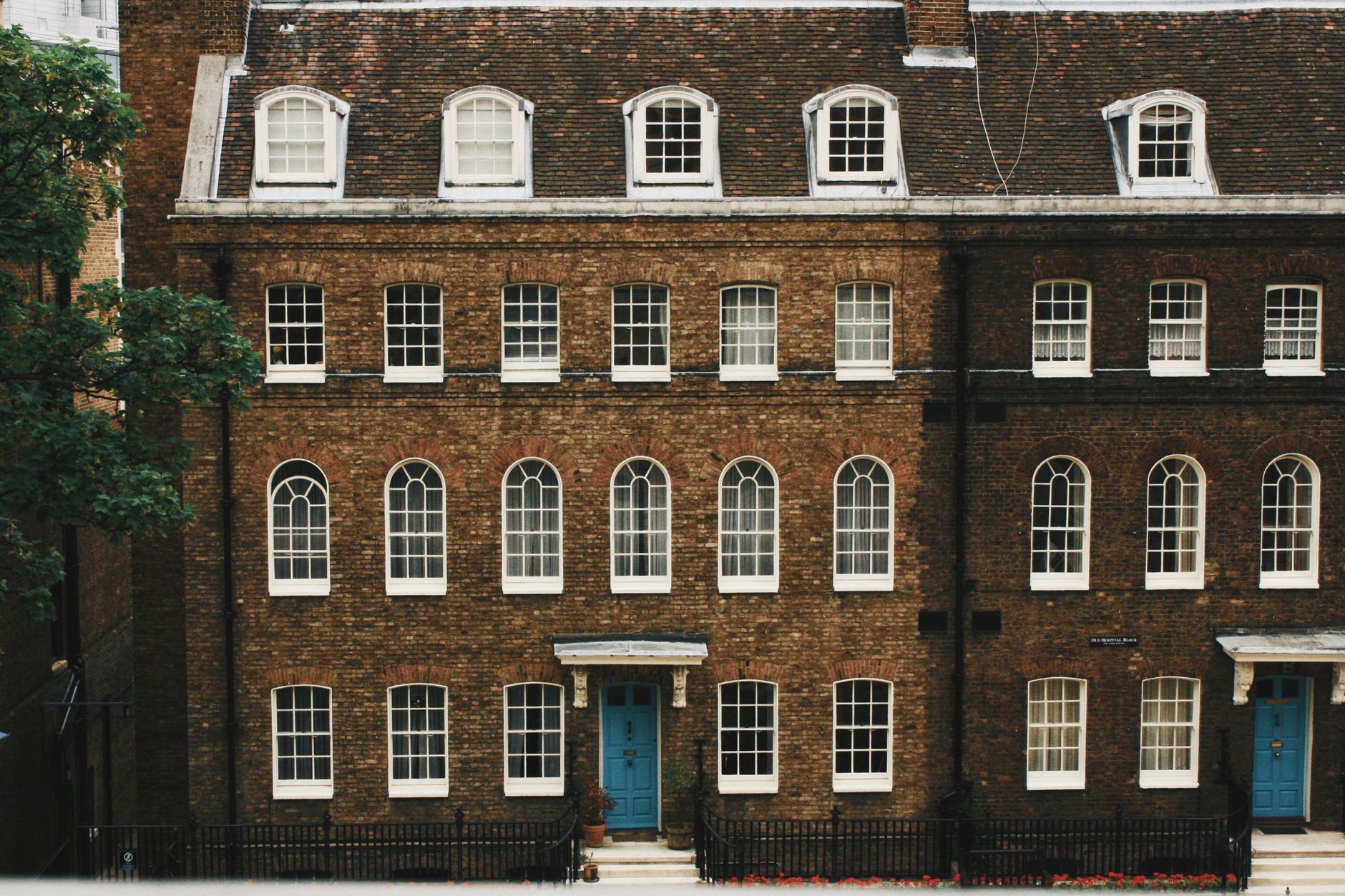 Historic facade of a classic brown brick building with arched windows in London.