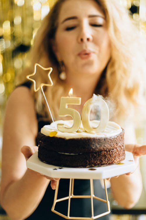 Free Woman in Black Top Holding White and Black Cake Stock Photo