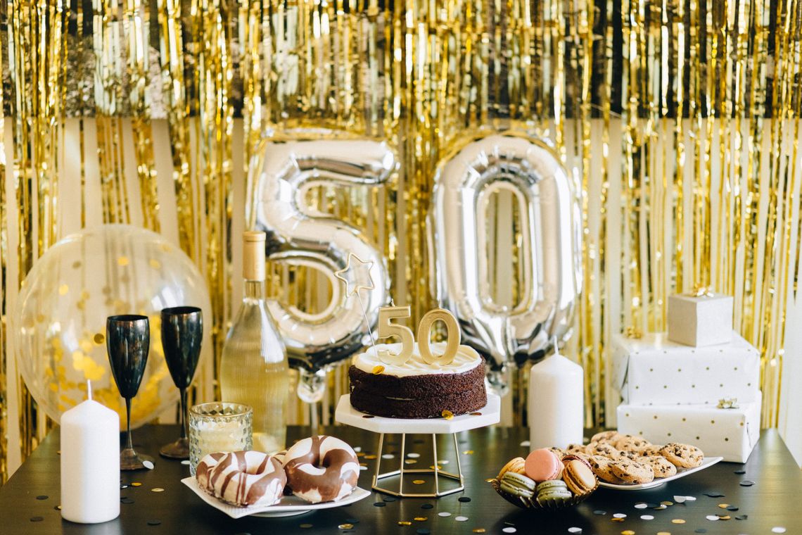 Stylish milestone birthday setup with balloons, gifts, cake, and celebration decorations