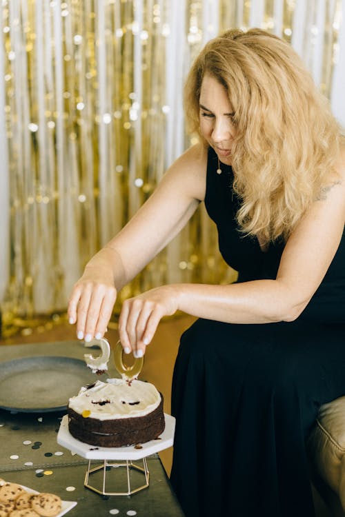 Free Woman in Black Dress Removing the Candles on Her Cake Stock Photo