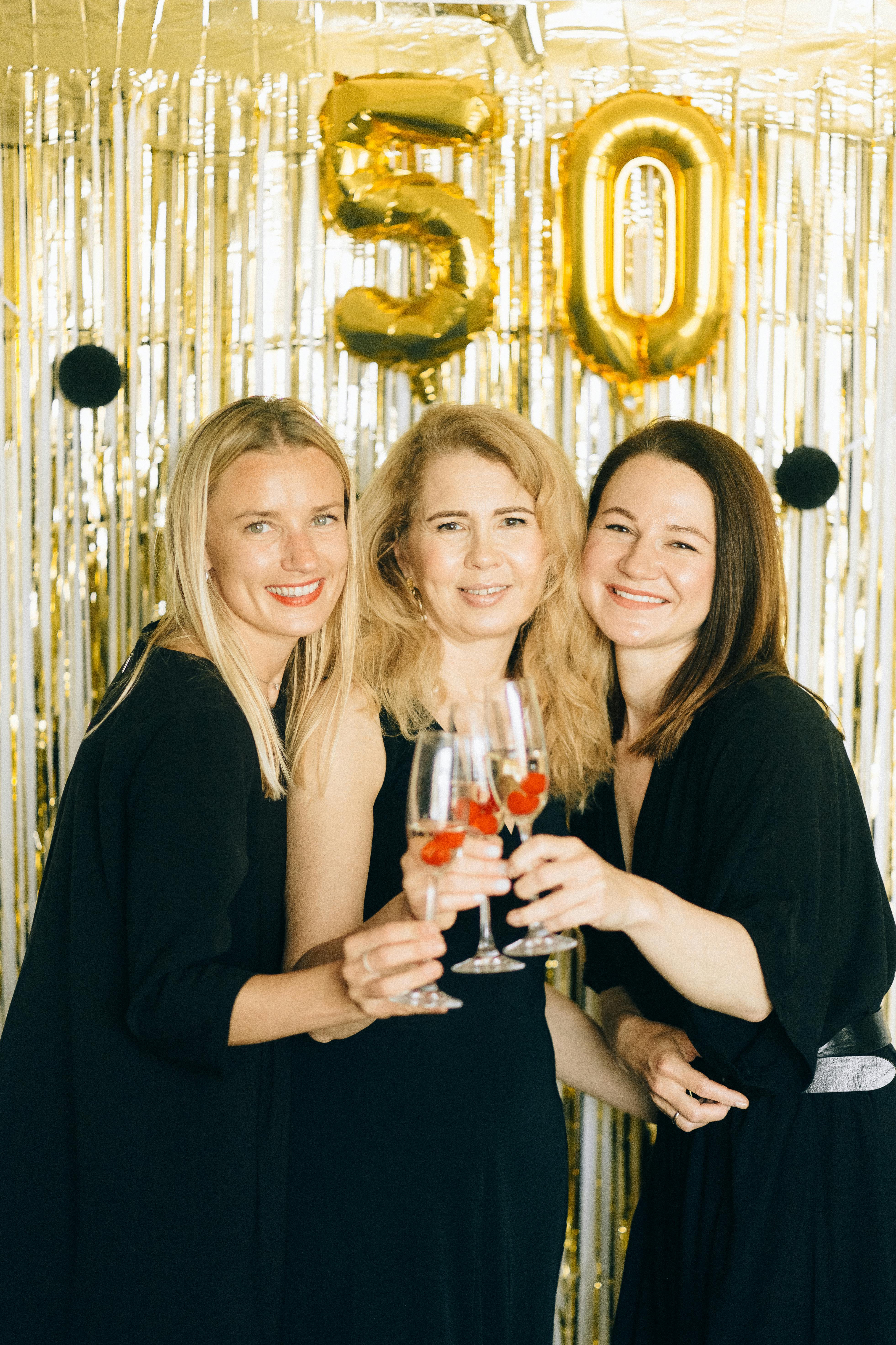 three smiling women holding drinking glasses