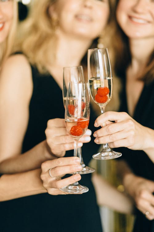 Free Woman Holding Clear Glasses of Champagne Stock Photo