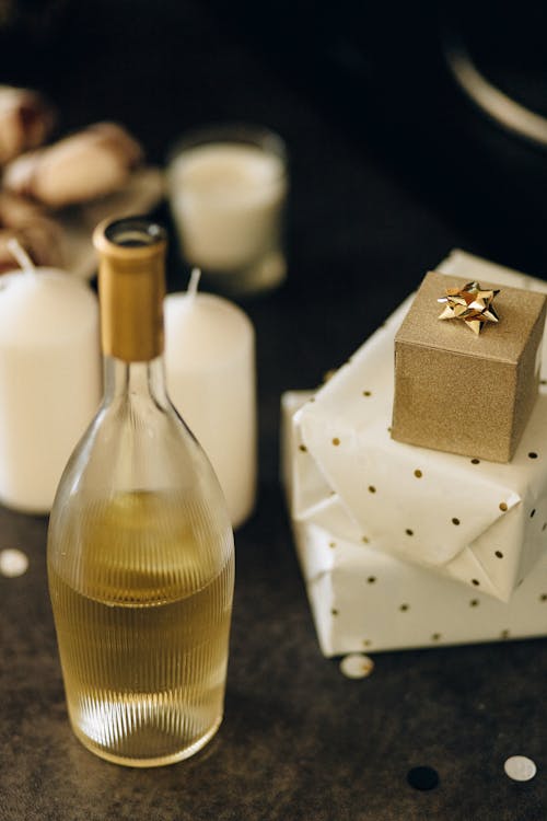 Clear Glass Bottle of Wine Beside the Gifts
