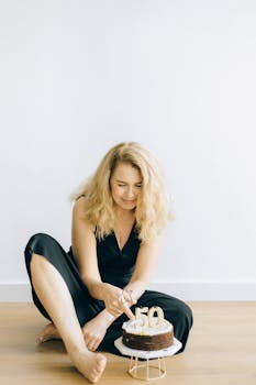 Middle-aged woman cutting into a birthday cake marked with the number 50.