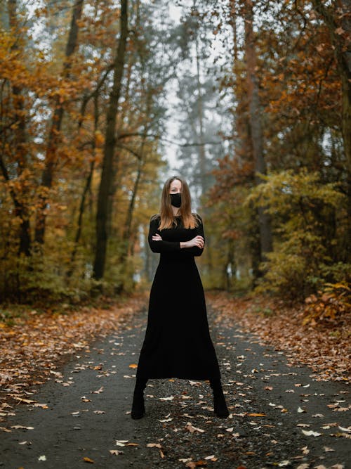 Woman in Black Dress Standing on Unpaved Pathway