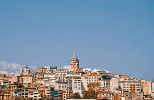 A scenic view of Galata Tower surrounded by Istanbul's skyline on a clear day, capturing Turkey's vibrant architecture.