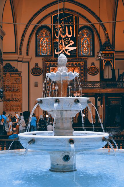 A detailed fountain inside a historic mosque with intricate Islamic art and architecture.