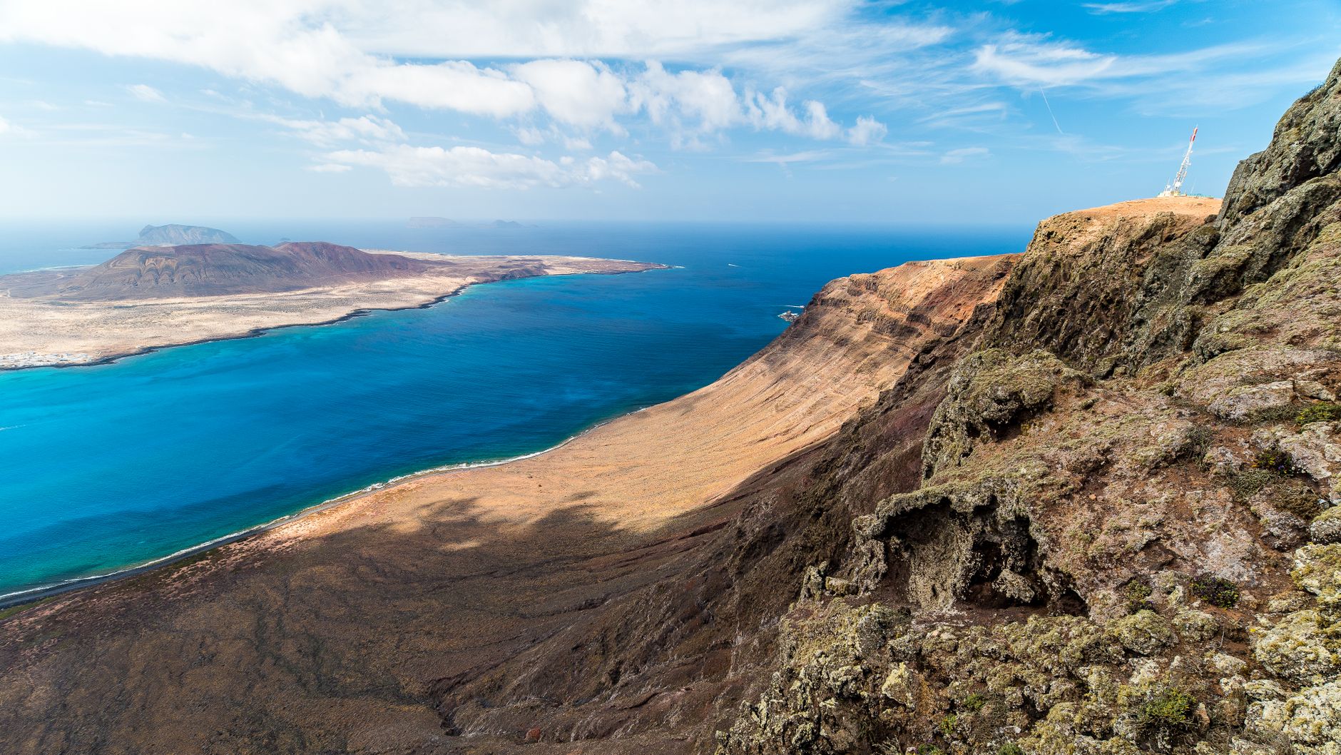 A breathtaking aerial view of the rugged coastline and clear blue waters of Lanzarote, Spain.