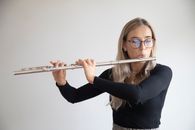 Woman in Black Long Sleeve Shirt Playing Flute