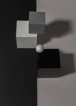 Abstract geometric shapes composition in a minimal studio environment with strong contrast.