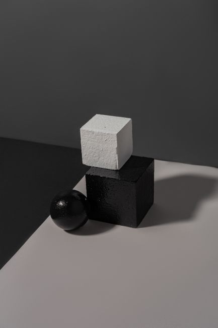 Minimalist composition of geometric shapes on a gray background in a studio setting.