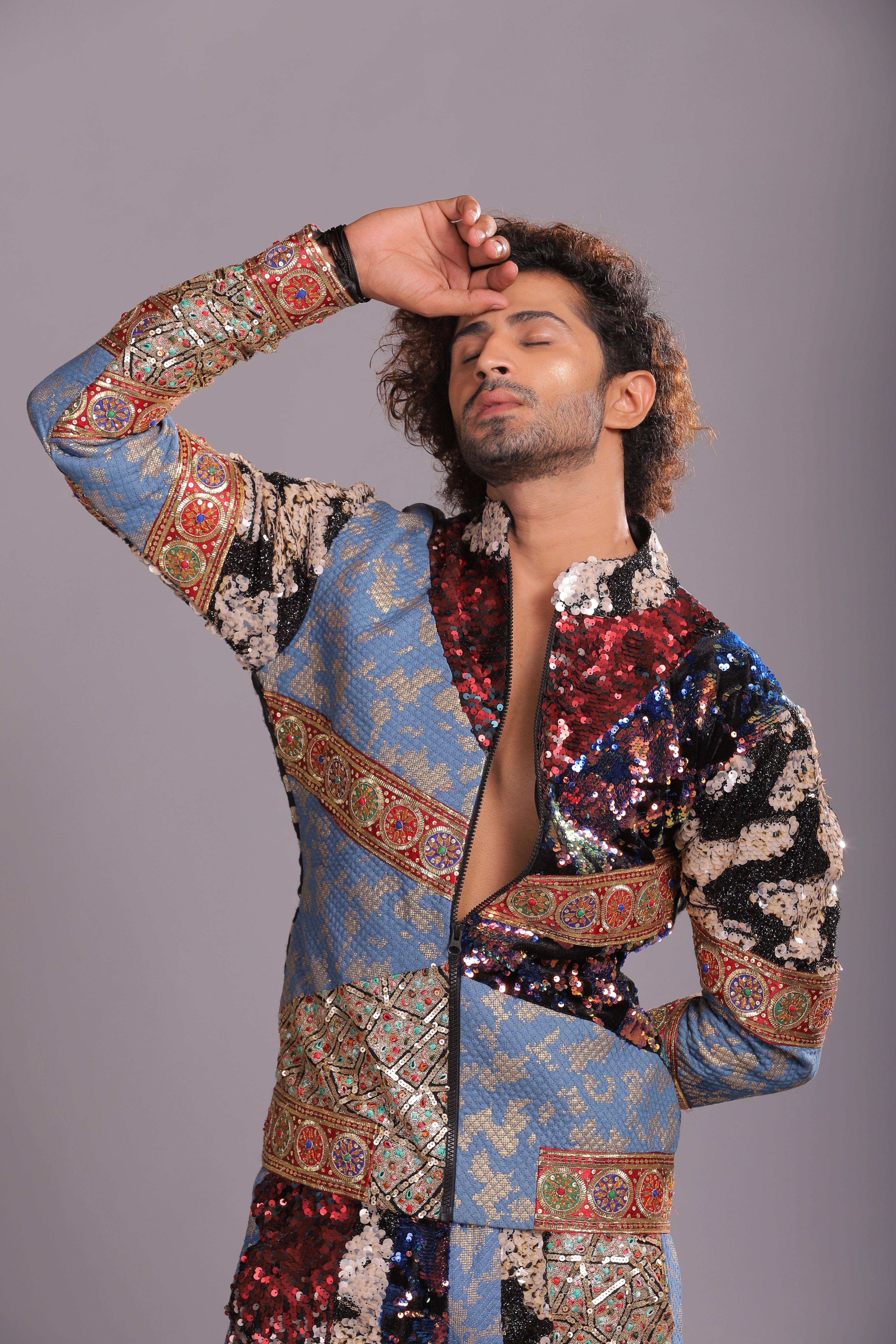 Portrait of a handsome man posing stylishly in a vibrant, patterned jacket. Studio shot.