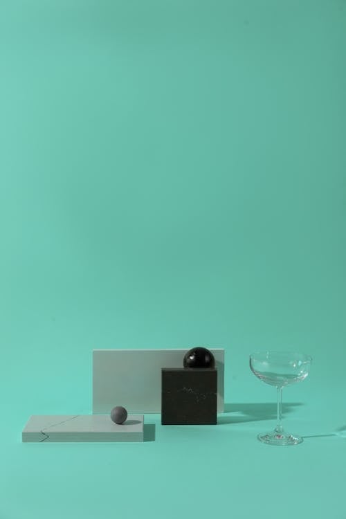 Wine Glass and Marble Geometric Shapes on a Flat Surface