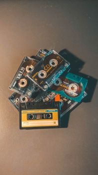 A collection of retro cassette tapes in a top-down view on a black background, showcasing vintage audio nostalgia.