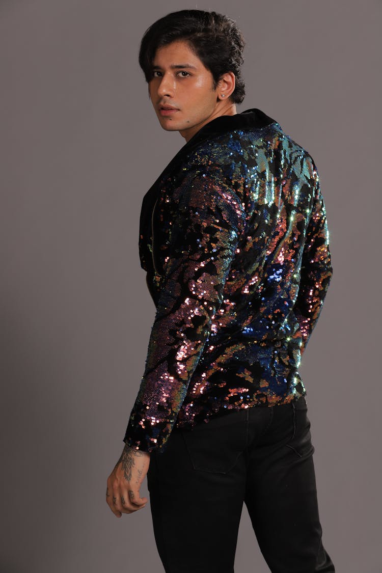 A Man Wearing Glittery Jacket Looking Over Shoulder