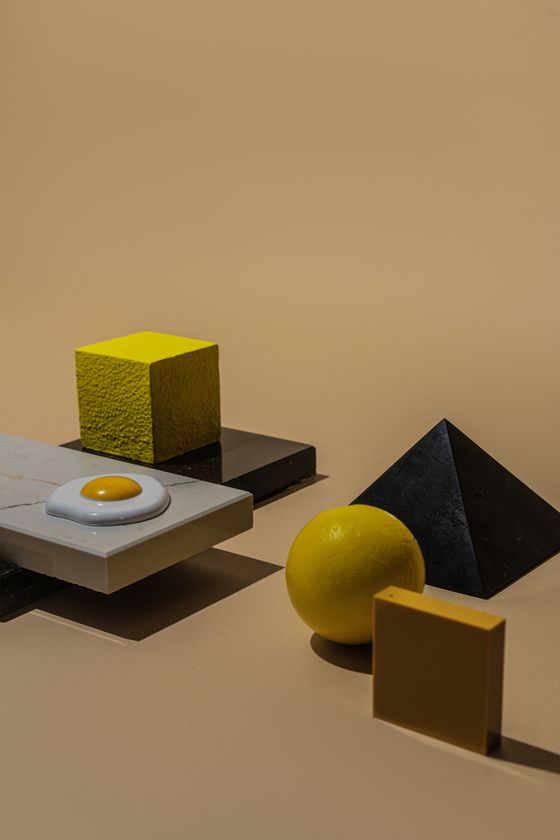 Yellow cube and marble slab by Mikhail Nilov on Pexels