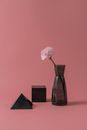 Pink and White Flowers in Vase Beside Two Black Boxes