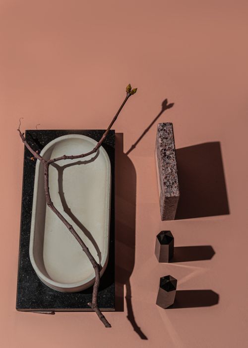 Free A creative still life featuring geometric shapes, a ceramic dish, and a natural twig on a warm background. Stock Photo