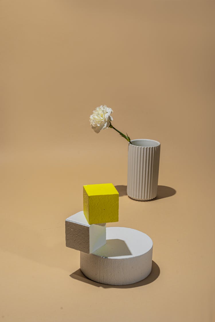 Yellow And White Cube Stacked On A White Round Object