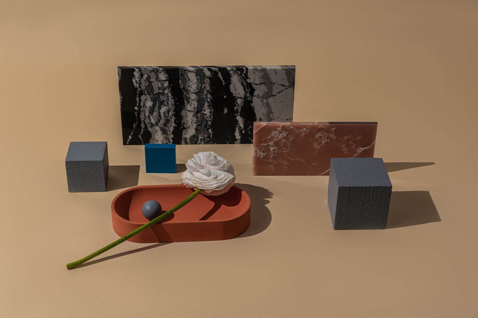 Composition of Blocks in in Different Shapes and a Flower Lying on a Ceramic Dish