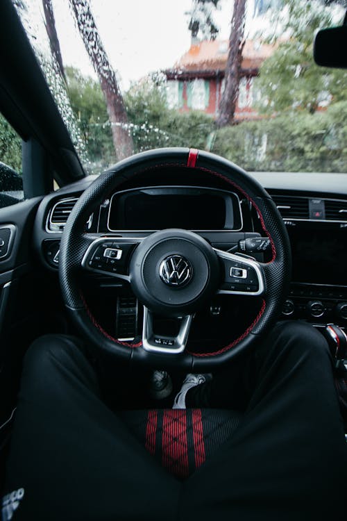 A Person Sitting on the Front Seat of a Car in front of a Steering Wheel