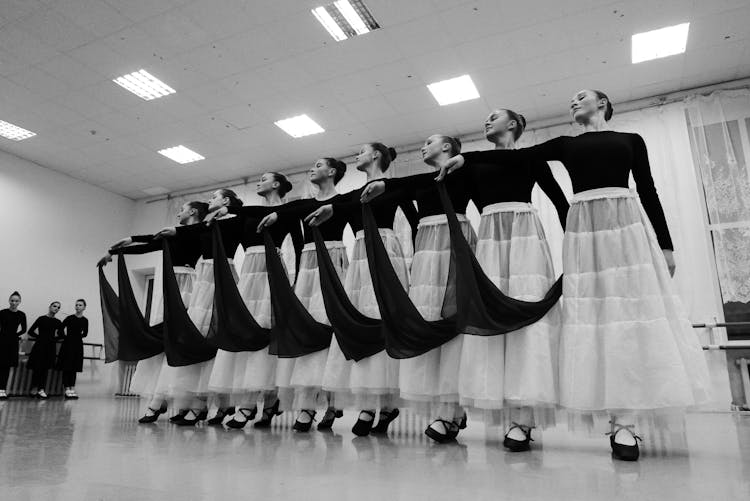 Teen Dancers Performing Choreographic Movement During Rehearsal In Hall