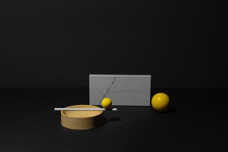 Still Life Composition Of Yellow And Gray Objects On Black Background 