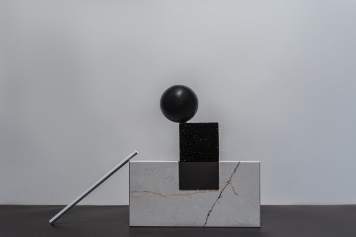 Geometric shapes and a marble block still life by Mikhail Nilov on Pexels