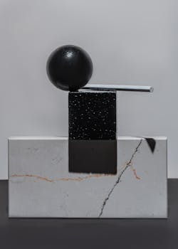 A sleek minimalist sculpture showcasing geometric shapes on a gray surface. Perfect for modern design themes.