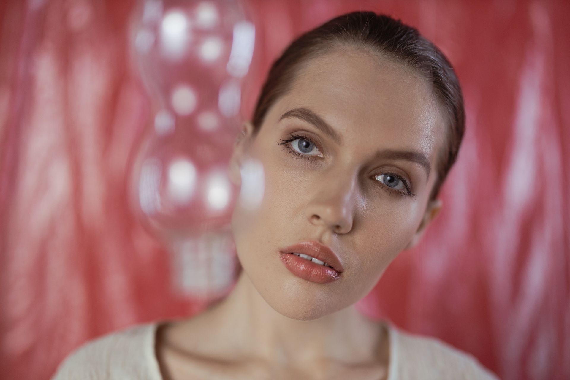 Elegant portrait of a woman with a creative blurred backdrop, emphasizing facial features and beauty.
